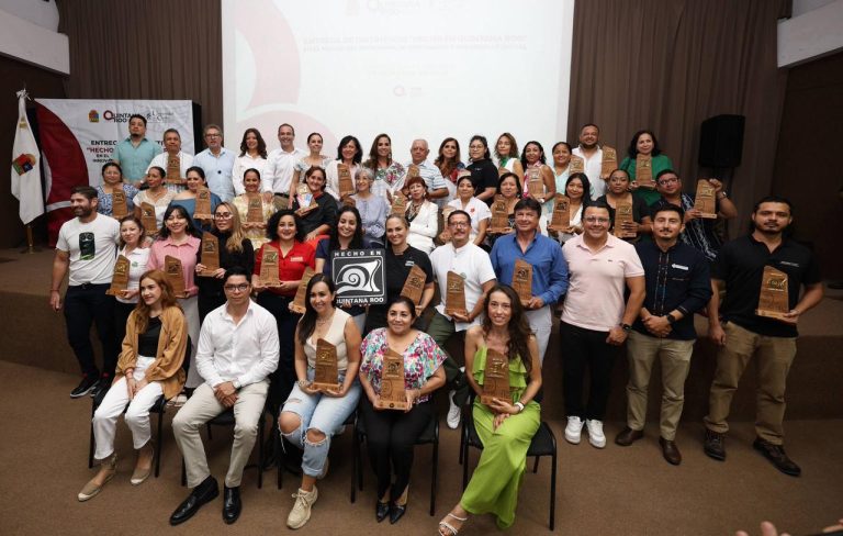 Ana Paty Peralta y Mara Lezama entregan el distintivo Hecho en Quintana Roo a artesanos locales.