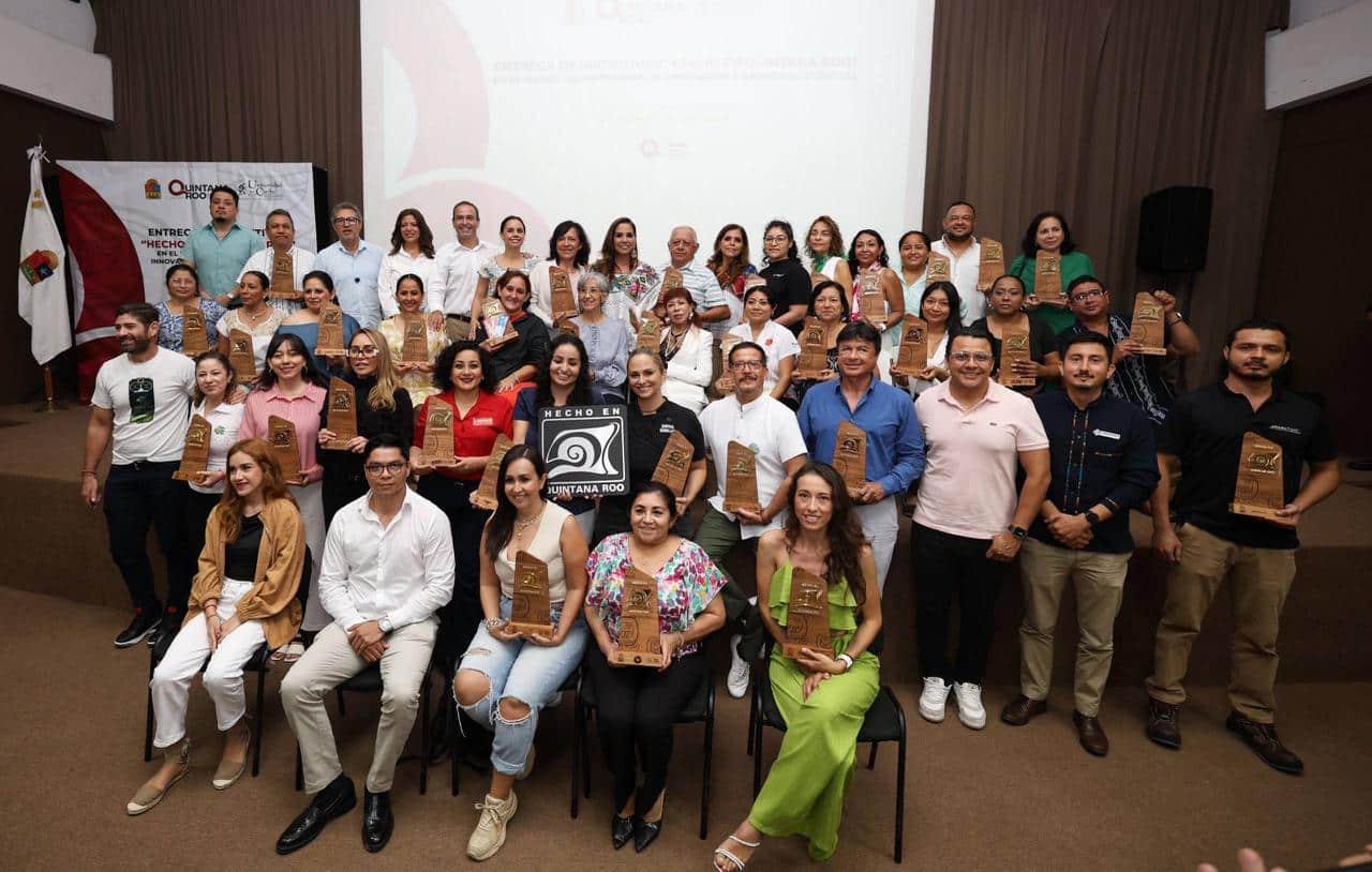 Ana Paty Peralta y Mara Lezama entregan el distintivo Hecho en Quintana Roo a artesanos locales.