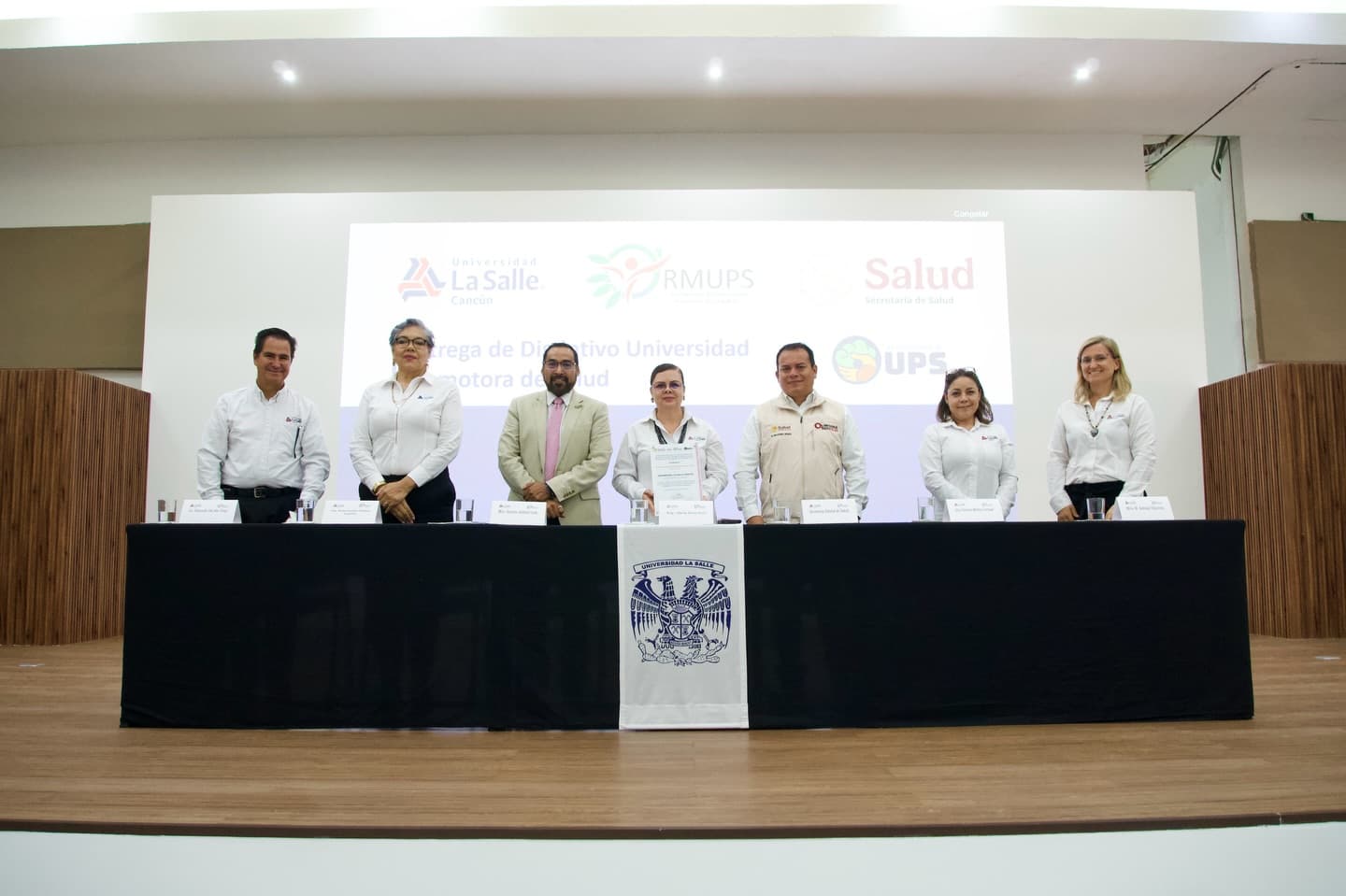 Fachada y comunidad estudiantil de la Universidad La Salle Cancún celebrando el distintivo de Universidad Promotora de la Salud.