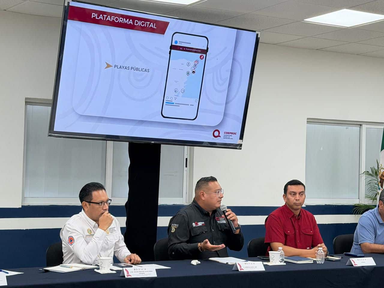 Reunión de autoridades de COEPROC y Protección Civil municipal en Playa del Carmen planificando estrategias.