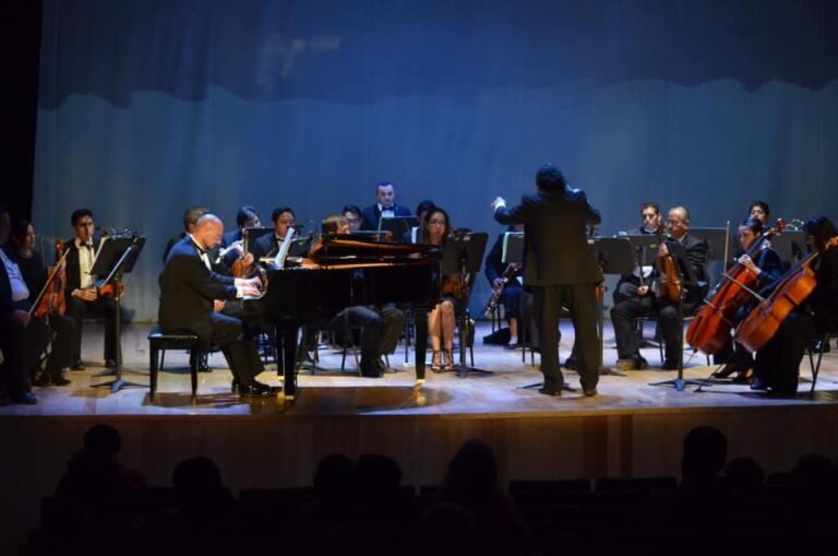 Músicos afinando instrumentos antes del debut de la Orquesta de Cámara Municipal de Cancún.