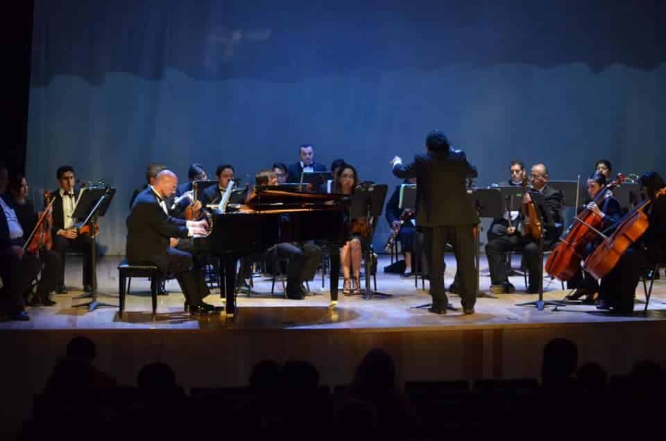 Músicos afinando instrumentos antes del debut de la Orquesta de Cámara Municipal de Cancún.